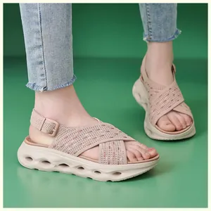 Close-up of pink fly-knit platform sandals with hollow out soles on feet