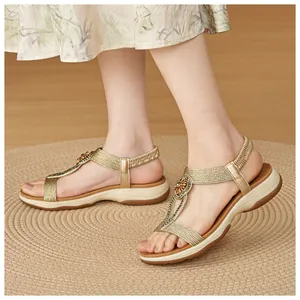 Close-up view of bohemian gold wedge sandals featuring rhinestone and woven strap details