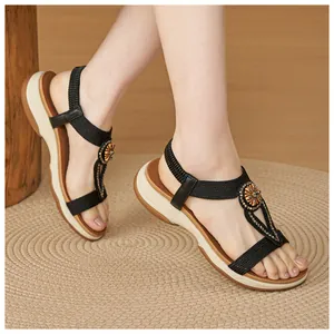 Detailed shot of bohemian wedge sandals with rhinestones worn on a model's feet