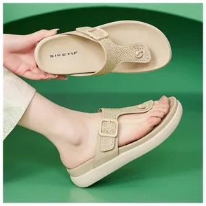 Dettaglio di sandali infradito beige con strass scintillanti e cinturino con fibbia regolabile.