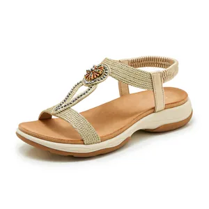 Detailed view of bohemian gold braided sandals with elegant rhinestone floral ornament