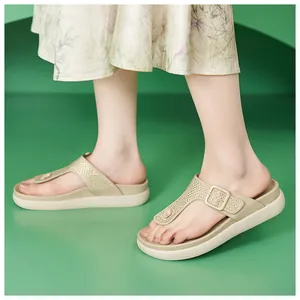 Dettaglio di sandali beige con strass e plateau indossati da una modella in gonna