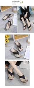 Lifestyle view of women's vintage wedge sandals with black straps and soft beige footbed.