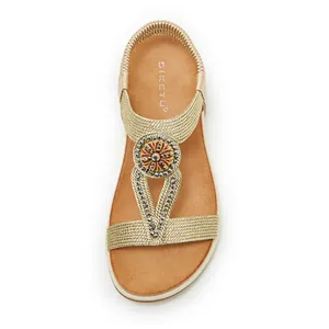 Top view detail of elegant bohemian gold sandals featuring rhinestone flower embellishments