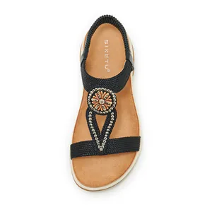 Detailed macro view of Bohemian rhinestone sandal featuring black braided straps