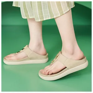 Vista ravvicinata di eleganti sandali infradito beige con plateau e cinturino a T.