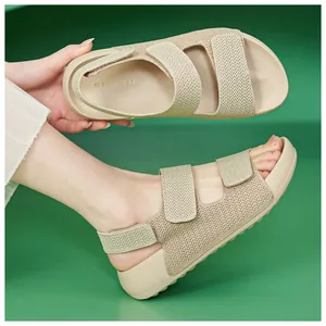 Detalle de sandalias tejidas beige con correas de velcro y suela blanda