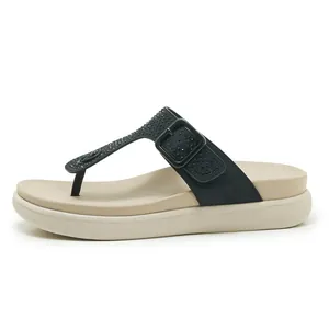 Vista laterale di sandali infradito neri con strass e comoda suola spessa beige