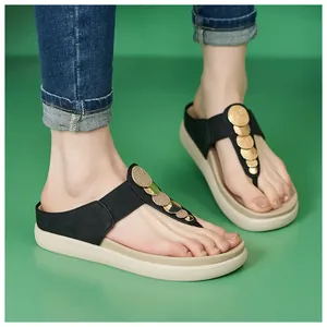 Vista dettagliata dei sandali platform a T da donna con decorazioni in strass dorati.