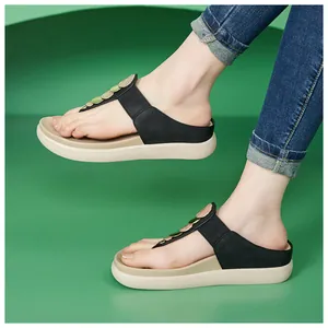 Infradito con zeppa nere da donna con decorazioni a disco metallico indossate.