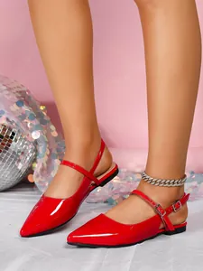 Close-up of elegant red patent leather pointed-toe flat sandals with a slingback strap.