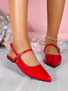 Detail view of elegant red patent leather pointed toe slingback flats with buckle straps