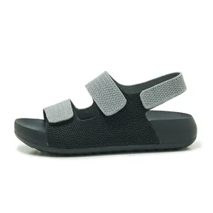 Vista lateral de sandalias tejidas negras para mujer con correas dobles grises y suela blanda