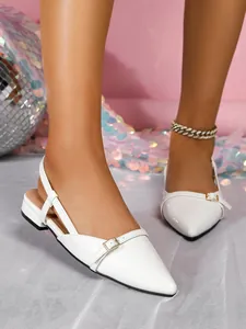 Close-up of white patent leather pointed-toe slingback sandals with elegant buckle