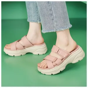 Nahaufnahme von rosa Chunky-Plateau-Sandalen mit Klettverschluss auf grünem Grund
