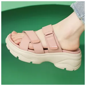 Nahaufnahme von rosa Plateausandalen mit klobiger weißer Sohle und verstellbarem Klettverschluss
