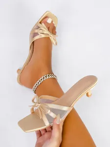 Elegantes sandalias doradas de tacón bajo con lazo de malla y punta abierta para verano.