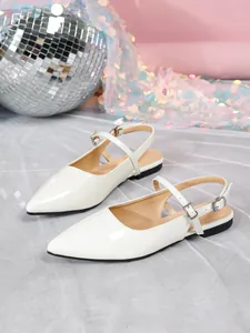 Detailed shot of elegant white patent leather slingback flats with buckle straps