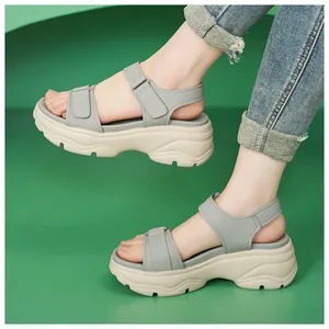 Detailed view of grey platform sandals featuring thick beige soles and adjustable Velcro straps