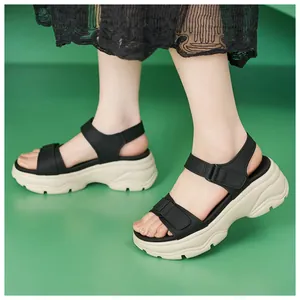 Close-up detail of women's black platform sandals featuring chunky beige soles and velcro straps