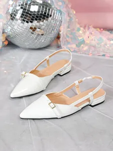 Detail shot of white patent leather pointed-toe slingback flat shoes with buckle
