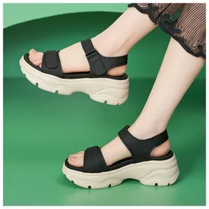 Side view of stylish black platform sandals with velcro straps on thick cream sole