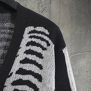 Gros plan sur le motif de squelette noir et blanc d'un cardigan en maille jacquard