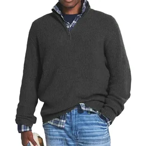 Detail of men's charcoal grey quarter-zip ribbed knit sweater layered with plaid shirt.