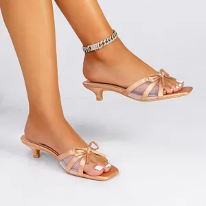 Elegantes mules de tacón bajo color champán con lazo y detalles de malla para mujer