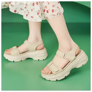 Detailed side view of beige platform sandals with velcro straps worn by a model