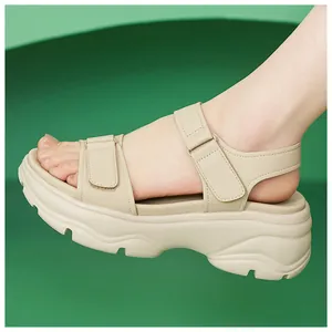 Close-up detail of beige platform sandals with adjustable velcro straps and soft sole
