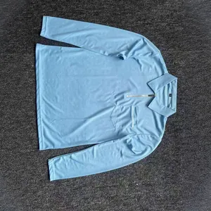 Polo da uomo azzurra a maniche lunghe con collo a zip e taschino sul petto