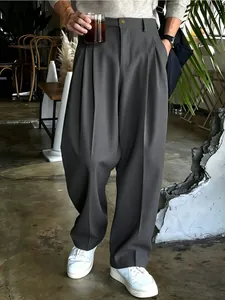 Dettaglio dei pantaloni da abito larghi a pieghe da uomo in un'elegante finitura grigio scuro