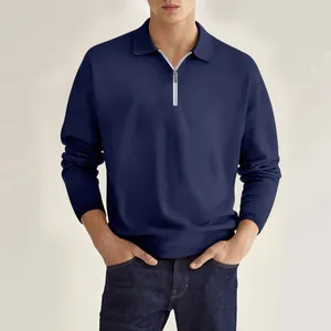 Vista detallada de un polo de manga larga azul marino con cuello con cremallera metálica.