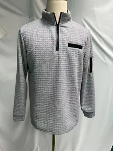 Detailed view of gray waffle texture on men's half-zip polo shirt with sleeve pocket