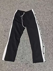 Close-up detail of side snap-button closure on black and white basketball sports pants