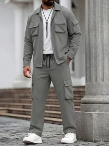 Modern grijs heren cargo set met multi-pocket jas en bijpassende broek buiten gedragen.