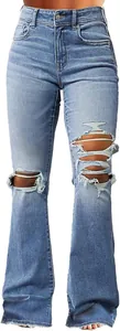 Close-up detail of vintage blue ripped flare jeans featuring high waist and frayed hem edges