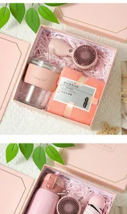 Détail d'un coffret cadeau rose avec mini ventilateur, gobelet en verre et serviette.