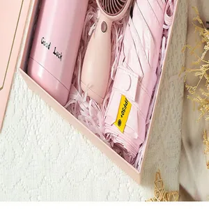 Vue détaillée d'un coffret cadeau rose avec gourde, mini ventilateur et parapluie UV