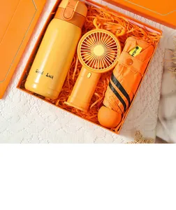 Coffret cadeau orange vif avec bouteille isotherme, ventilateur portable et parapluie.