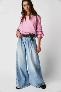 Fashion model wearing vintage light wash wide-leg denim jeans with pleated front detail