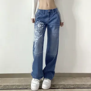 Detailed view of white floral graphic print on blue wide-leg denim jeans for women