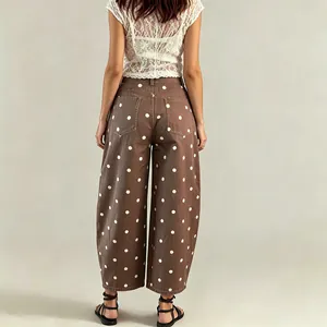Detailed back view of women's brown wide-leg curved denim jeans with white polka dots