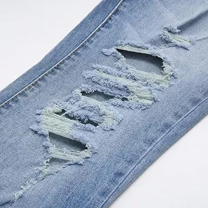 Macro view of distressed ripped details on vintage light blue denim flared jeans