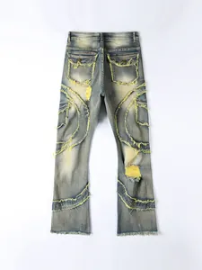 Detailed rear view of distressed flared denim jeans with yellow frayed edges and patches