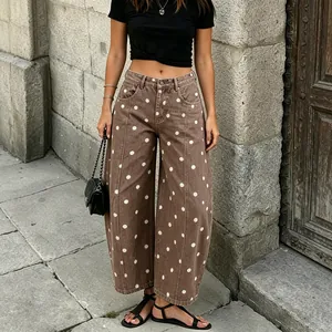 Detailed view of women's brown polka dot wide leg curved jeans with high waist design