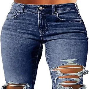 Close-up detail of blue high-waisted distressed skinny jeans with ripped thigh elements