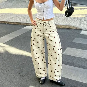 Detailed view of women's baggy polka dot jeans with curved leg and low-waist fit.