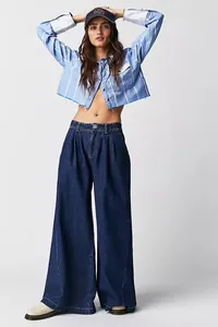 Detail view of high-waisted dark blue wide-leg denim jeans with pleated waist for women.